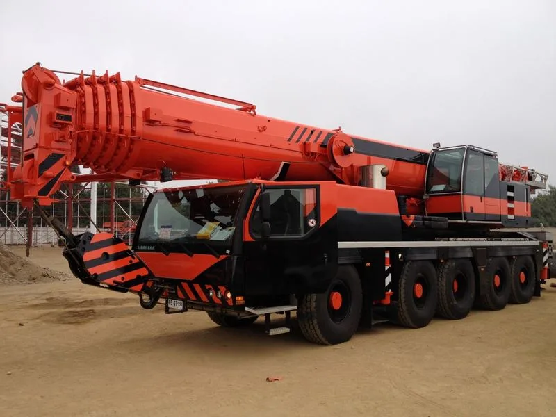 Grúa telescópica de Crane Service con la pluma extendida sobre los estabilizadores, en faena a cielo abierto