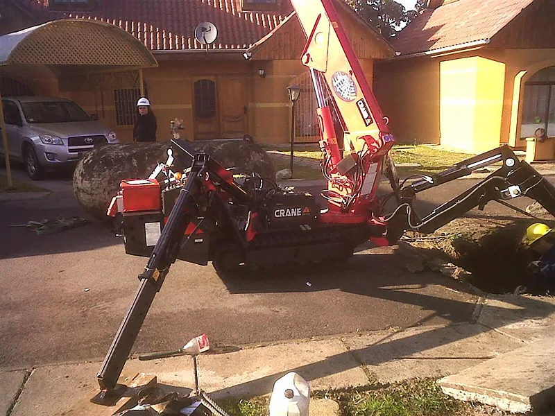 Minigrúa araña de Crane Service con los cuatro estabilizadores desplegados en un patio