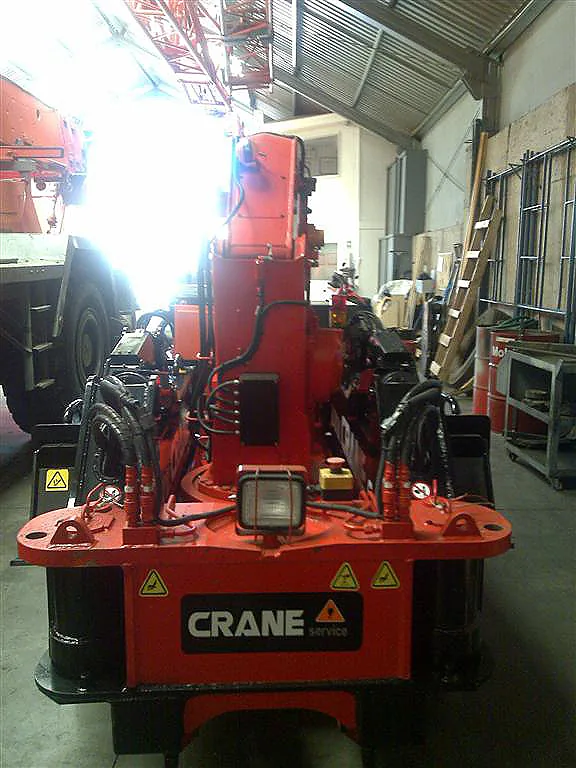 Minigrúa araña de Crane Service, rotulada www.crane.cl, operando dentro de un pasillo interior