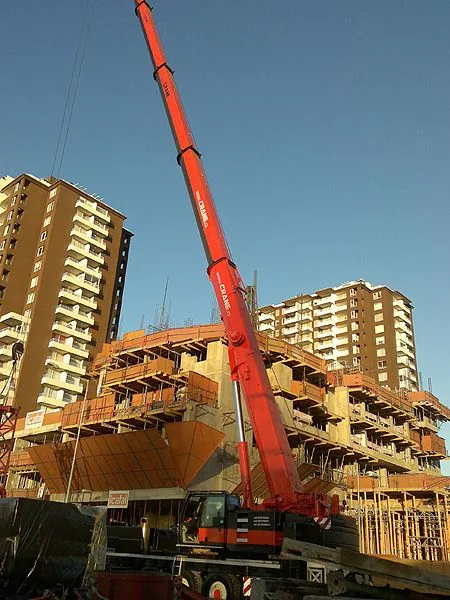 La grúa de 100 toneladas montando encofrados en un edificio en construcción, entre dos torres ya terminadas